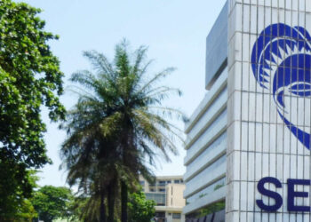 A man walks past the headquarter's of Gabon's energy and water company SEEG (Societe d'energie et d'eau du Gabon) on March 10, 2010 in Libreville. Members of "SOS Consommateurs", a consumer's association have started a hunger strike in protest against SEEG, a subsidary of the French company Veolia. AFP PHOTO / COUMBA SYLLA / AFP PHOTO / COUMBA SYLLA